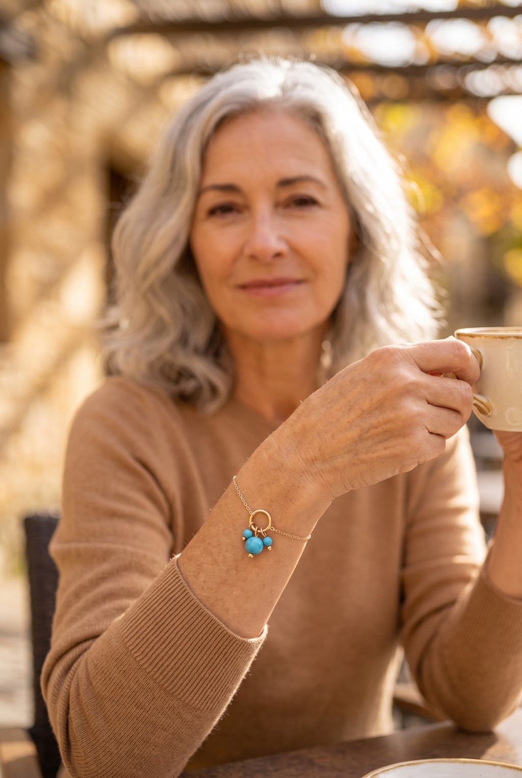 DOMITILLE — pulsera de cadena fina con colgante de cuentas turquesa, en una terraza en otoño