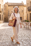 ARLETTE — bolso shopper estilo rafia de paja camel y burdeos con bordado "Oh Soleil", en una plaza mediterránea